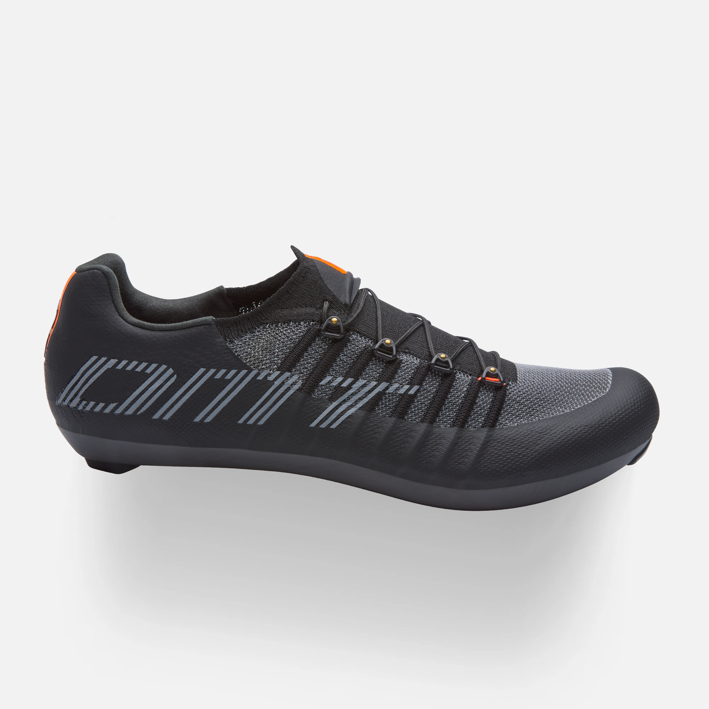 Scarpa da ciclismo DMT nera, vista laterale, con tomaia in maglia traspirante, lacci neri e dettagli arancioni, logo DMT grigio sul lato.